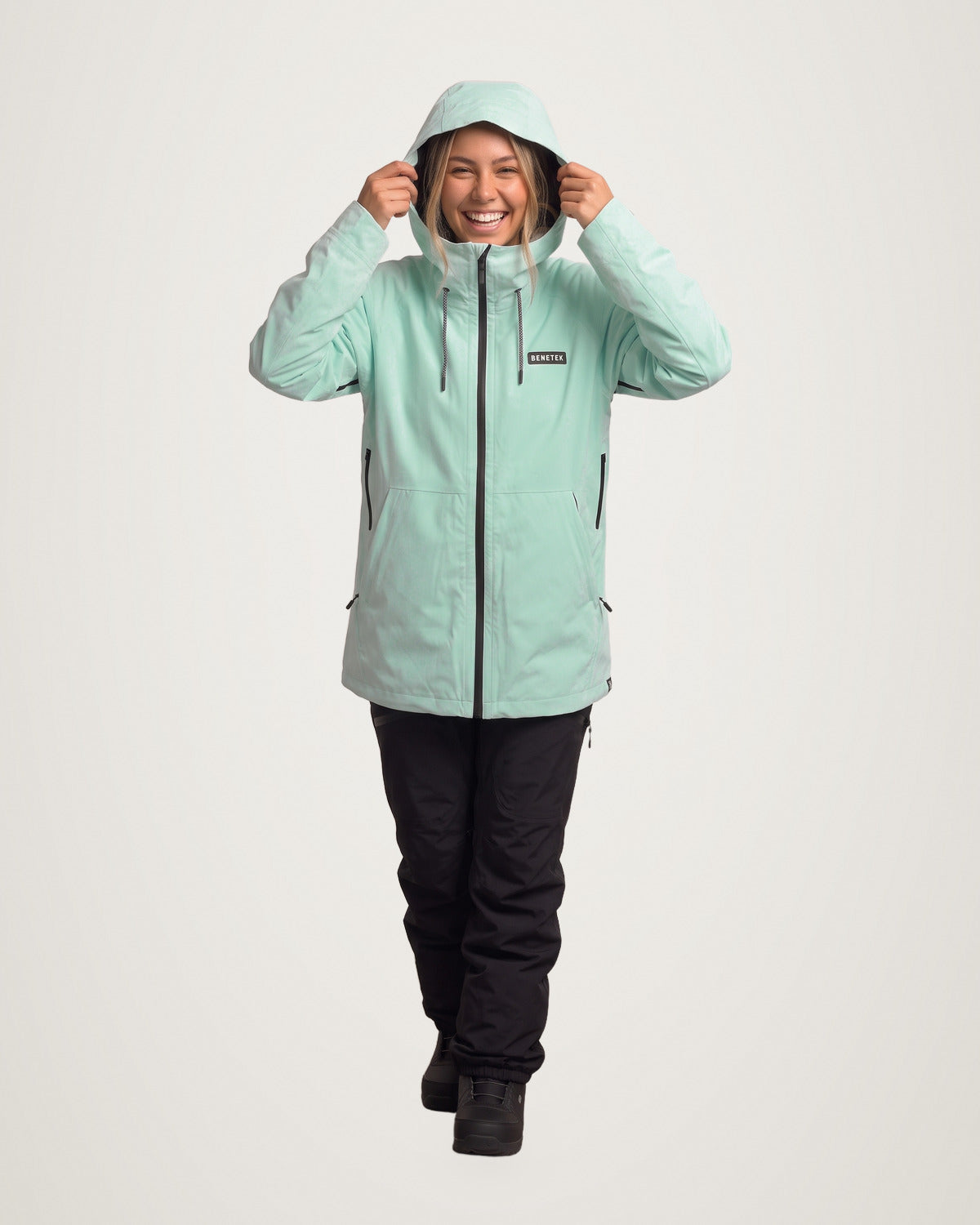 Sarah in the mint Focus Jacket, pulling the hood up